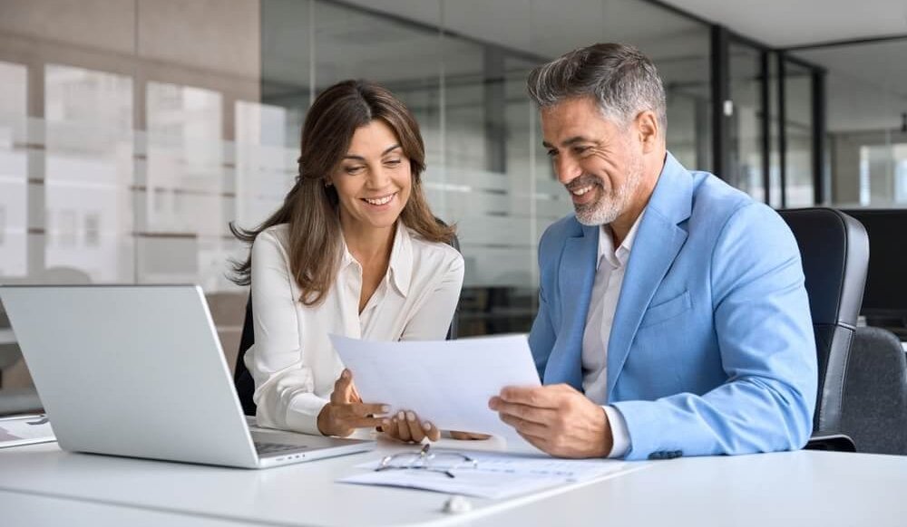 business owners looking at paper together and smiling