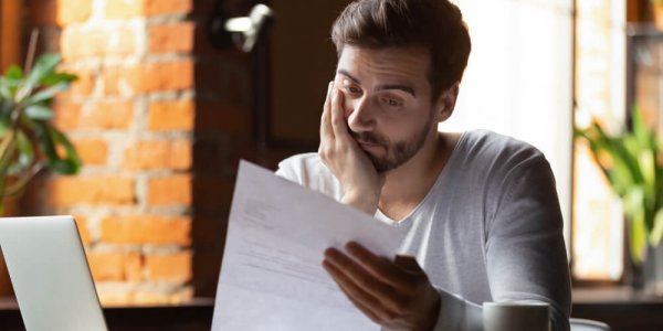 man looking disappointed at a piece of paper